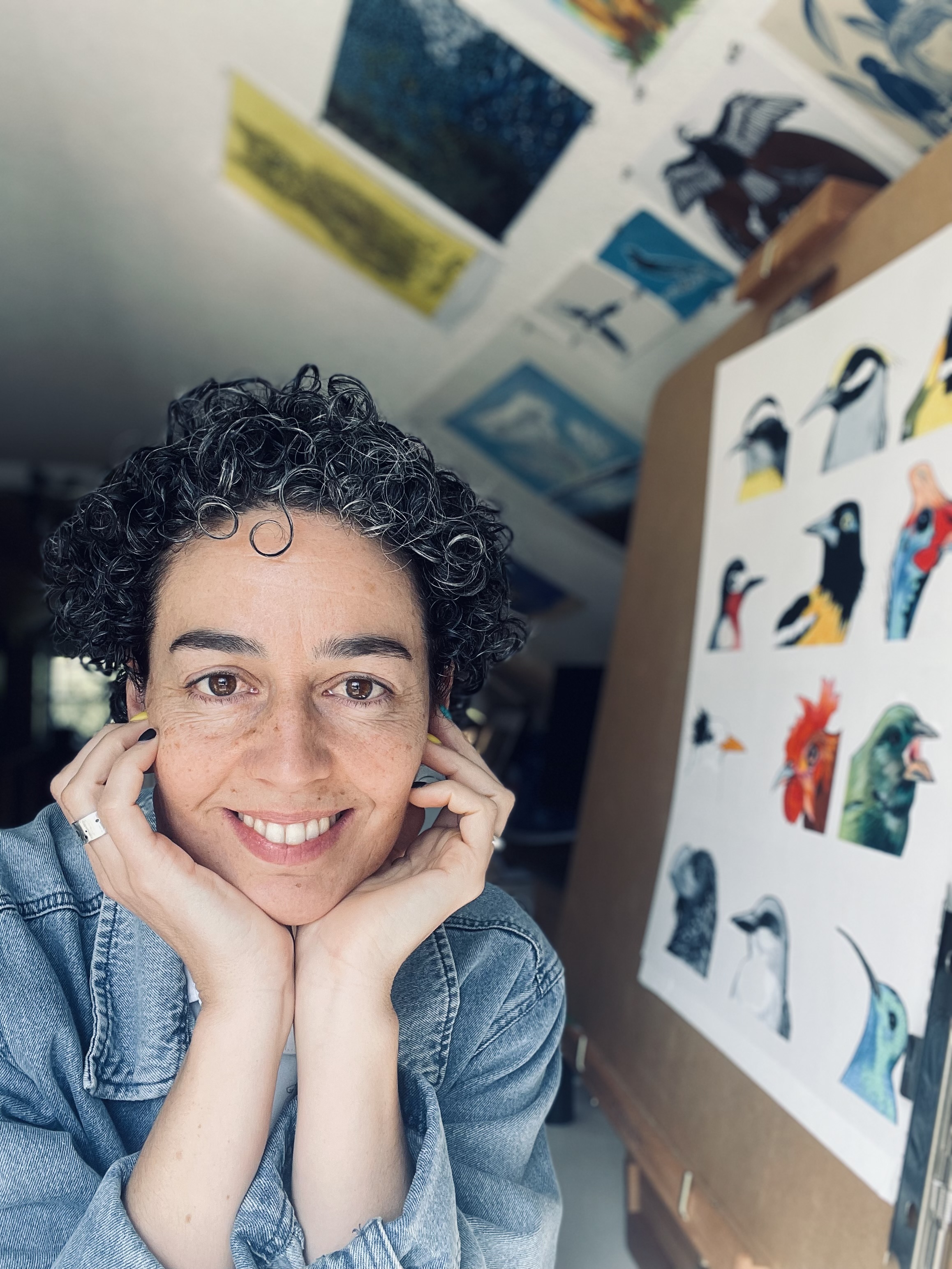 photo of Dr. Kacy McKinney, her face resting on her hands in a room with art on the walls